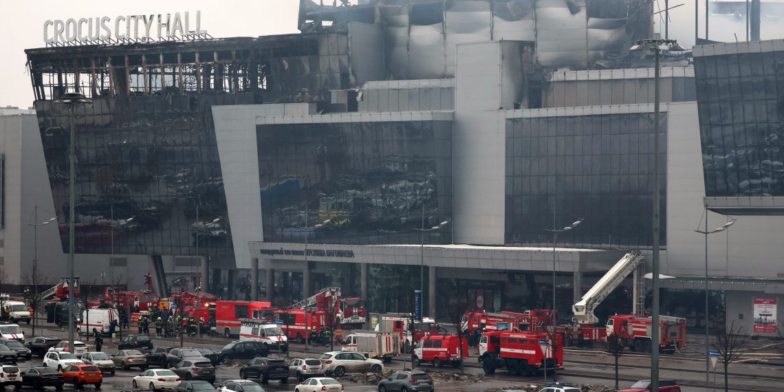 Members of emergency services work at the scene of the gun attack at the Crocus City Hall concert hall in Krasnogorsk, outside Moscow, on March 23, 2024. Gunmen who opened fire at a Moscow concert hall killed more than 60 people and wounded over 100 while sparking an inferno, authorities said on March 23, 2024, with the Islamic State group claiming responsibility. (Photo by STRINGER / AFP)