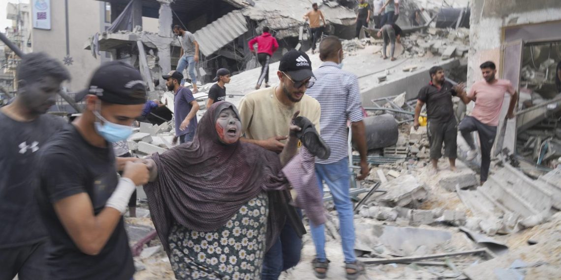 Palestinians evacuate survivors after the Israeli bombardment of the Gaza Strip in Deir Al-Balah, Sunday, Oct. 22, 2023. (AP Photo/Hatem Moussa)