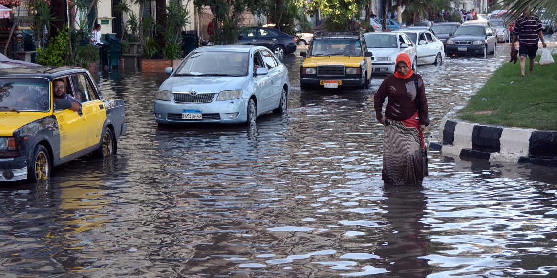 An Egyptian woman walks in a flooded street in Egypt's northern coastal city of Alexandria, following heavy rains, on October 25, 2015.  AFP PHOTO / STR (Photo by STR / AFP)