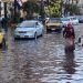 An Egyptian woman walks in a flooded street in Egypt's northern coastal city of Alexandria, following heavy rains, on October 25, 2015.  AFP PHOTO / STR (Photo by STR / AFP)