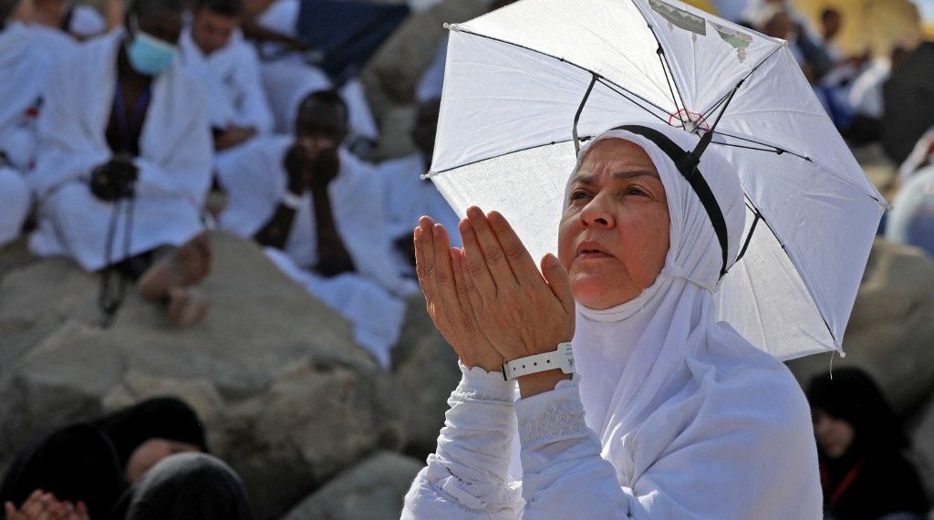 A Muslim woman prays atop Mount Arafat, also known as Jabal al-Rahma (Mount of Mercy), southeast of the Saudi holy city of Mecca, during the climax of the Hajj pilgrimage, on July 8, 2022. (Photo by Christina ASSI / AFP)