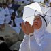 A Muslim woman prays atop Mount Arafat, also known as Jabal al-Rahma (Mount of Mercy), southeast of the Saudi holy city of Mecca, during the climax of the Hajj pilgrimage, on July 8, 2022. (Photo by Christina ASSI / AFP)