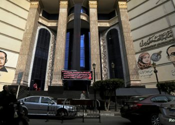 People and vehicles move past a black sign that reads "The press; It is not a crime" in front of the Egyptian Press Syndicate's headquarters in downtown Cairo, Egypt, November 20, 2016. REUTERS/Mohamed Abd El Ghany