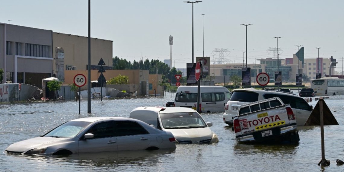 Cars are stranded on a flooded street in Dubai on April 19, 2024. Three workers from the Philippines have died in heavy flooding in the United Arab Emirates, Filipino officials announced, as the desert country struggled April 19 to recover from record rains. (Photo by Giuseppe CACACE / AFP)