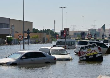 Cars are stranded on a flooded street in Dubai on April 19, 2024. Three workers from the Philippines have died in heavy flooding in the United Arab Emirates, Filipino officials announced, as the desert country struggled April 19 to recover from record rains. (Photo by Giuseppe CACACE / AFP)