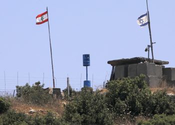 A picture taken on July 12, 2020 near the northern Israeli town of Shtula shows the "blue line" sign, a demarcation line drawn by the UN to mark Israel's withdrawal from southern Lebanon in 2000, near the Lebanese village of Aita al-Shaab. (Photo by JALAA MAREY / AFP)