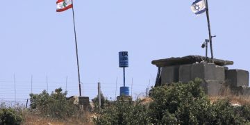 A picture taken on July 12, 2020 near the northern Israeli town of Shtula shows the "blue line" sign, a demarcation line drawn by the UN to mark Israel's withdrawal from southern Lebanon in 2000, near the Lebanese village of Aita al-Shaab. (Photo by JALAA MAREY / AFP)