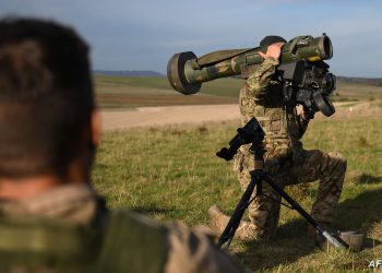 A British armed forces instructor holds a Javelin anti-tank system as he speaks with Ukrainian recruits during a five-week combat training course with the UK armed forces near Durrington in southern England on October 11, 2022. Ukrainian soldiers charge across a plain, brandishing rifles as smoke drifts from an explosion. But the recent recruits are not on the front line back home. They are in Britain, where the army is helping them to learn vital battlefield skills. (Photo by Daniel LEAL / AFP)