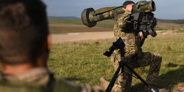 A British armed forces instructor holds a Javelin anti-tank system as he speaks with Ukrainian recruits during a five-week combat training course with the UK armed forces near Durrington in southern England on October 11, 2022. Ukrainian soldiers charge across a plain, brandishing rifles as smoke drifts from an explosion. But the recent recruits are not on the front line back home. They are in Britain, where the army is helping them to learn vital battlefield skills. (Photo by Daniel LEAL / AFP)